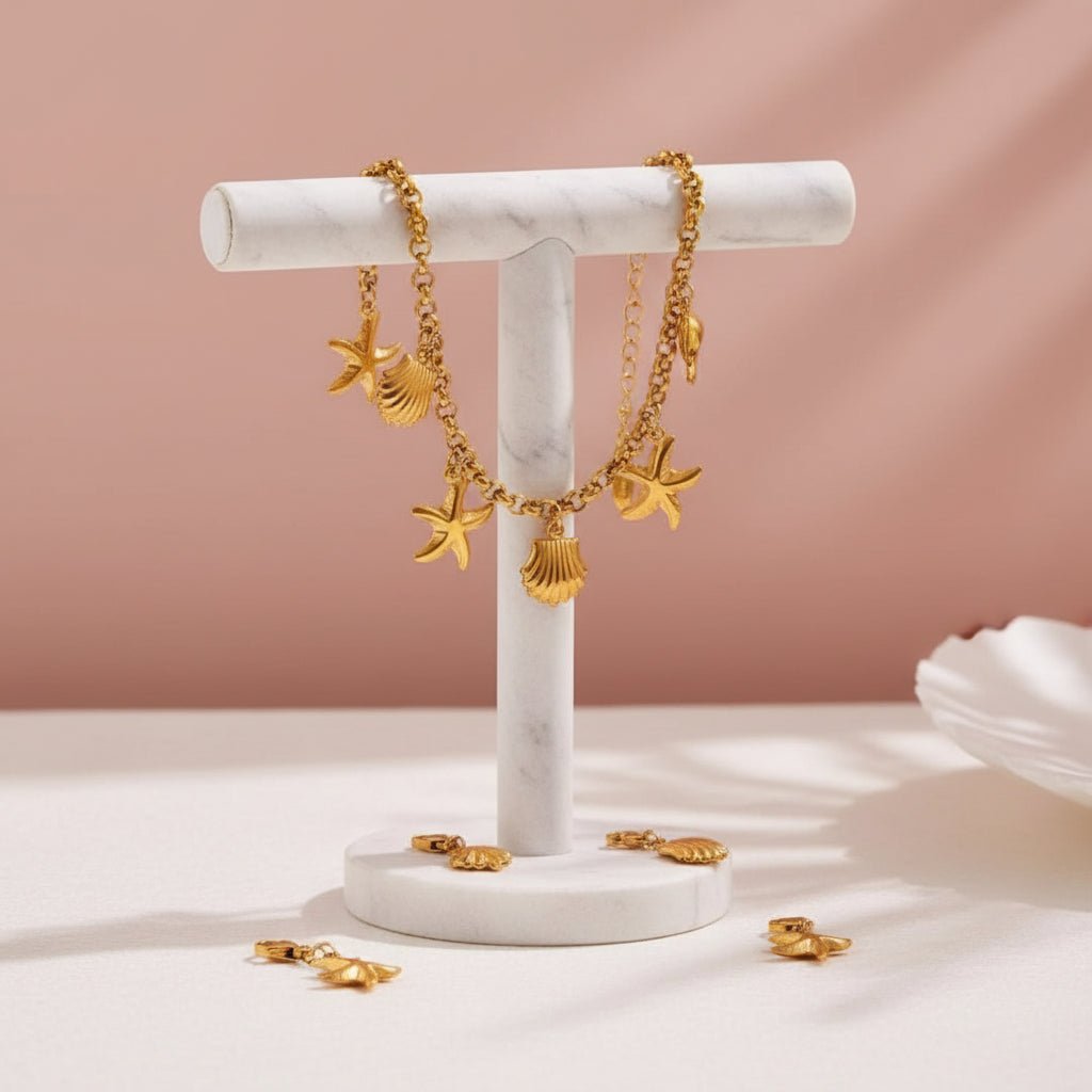 Gold charm bracelet with starfish, shell, and moon