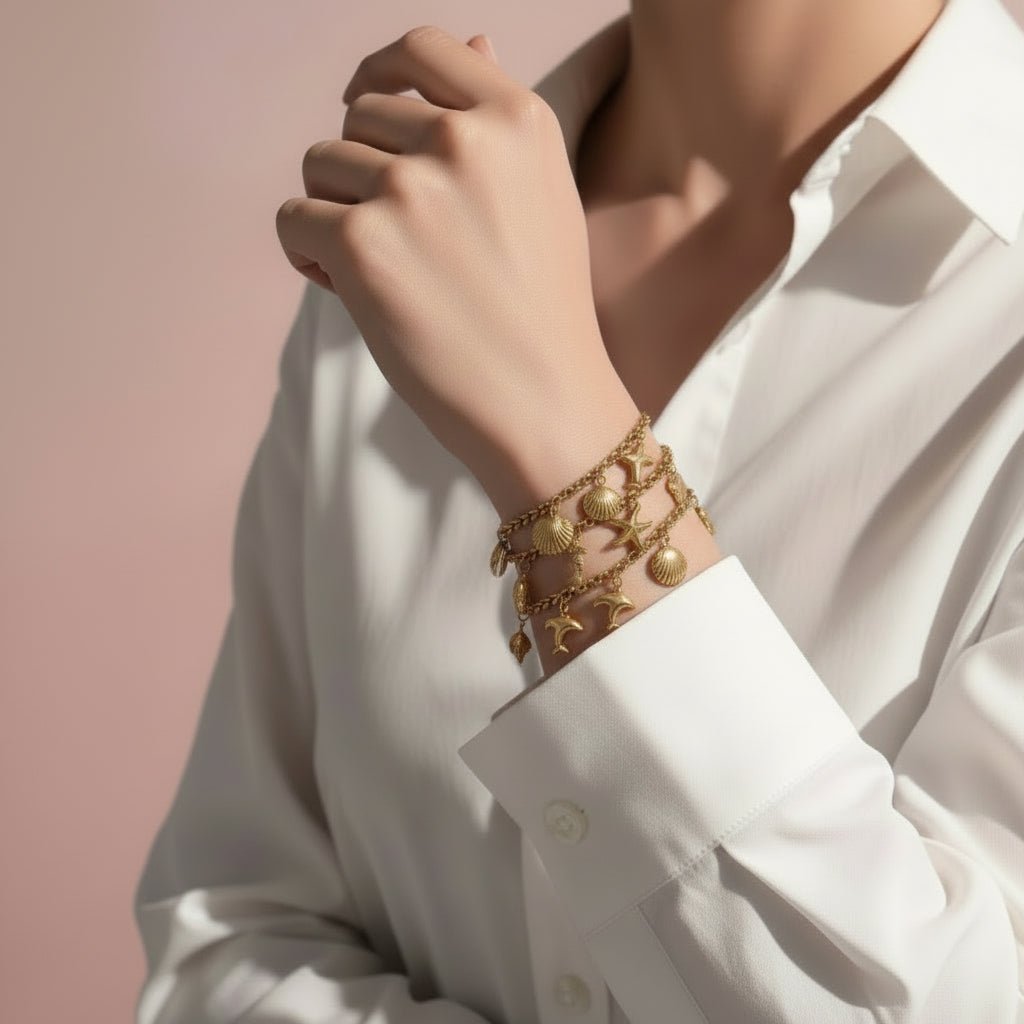 Gold charm bracelet with starfish, shell, and moon