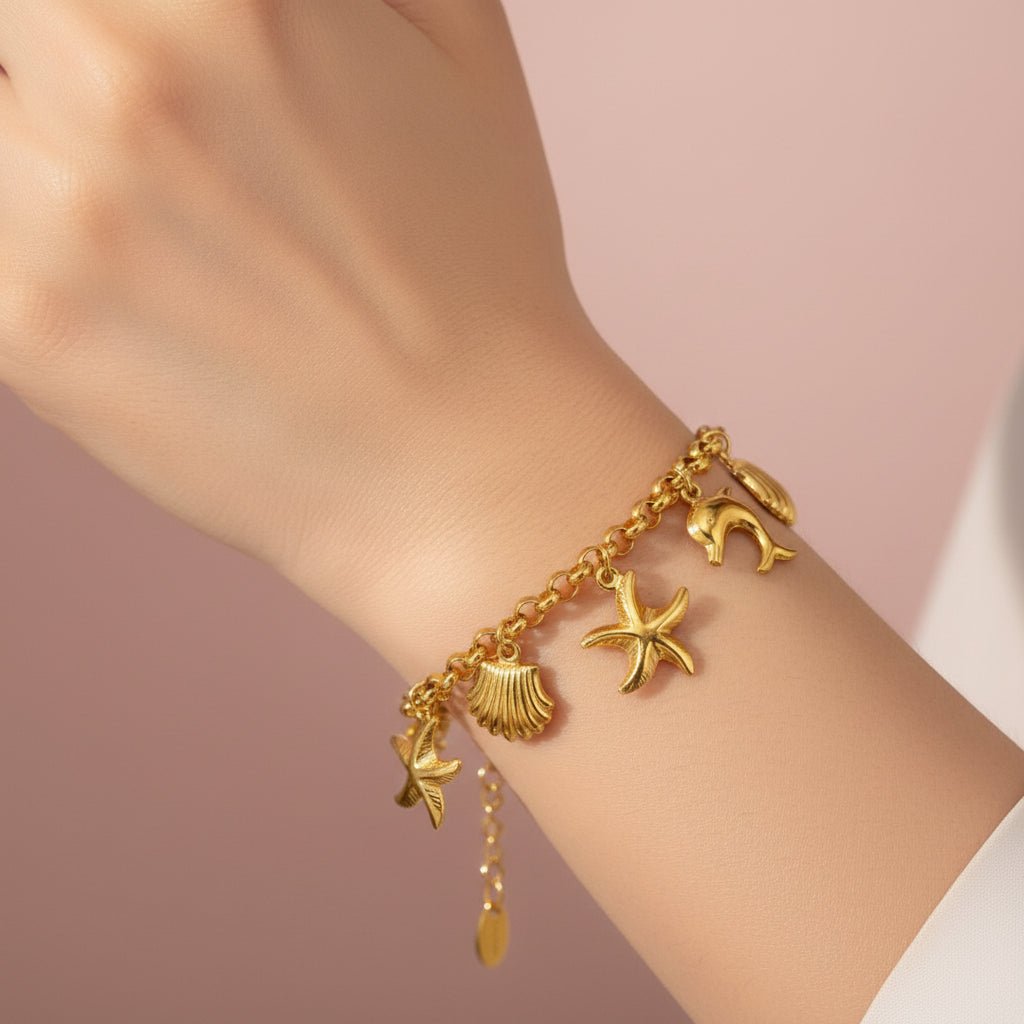 Gold charm bracelet with starfish, shell, and moon